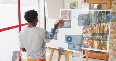 Artist painting urban cityscape with augmented reality overlays in bright studio