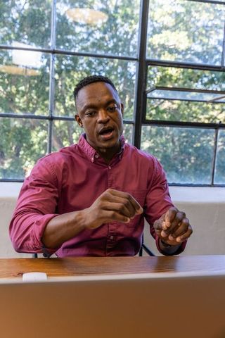 Businessman Engaging in Video Conference by Window in Modern Office