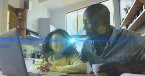 Father and Daughter Using Laptop with Light Effects Overlay