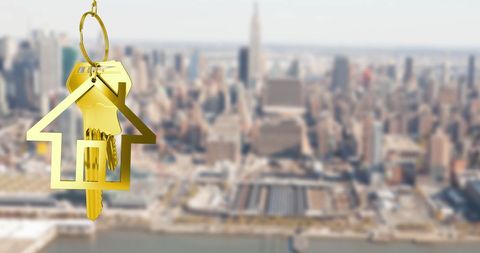 Golden House Key Hanging Over Blurred Cityscape