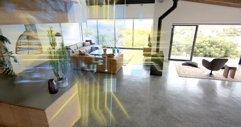 Tan sectional facing floor-to-ceiling glass in bright open-plan living with terrace views