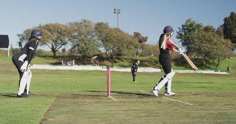 Female Cricket Players Practicing Batting and Wicketkeeping Outdoors