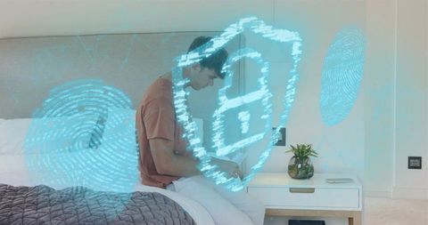 Man using mobile device on bed with holographic lock and fingerprint cybersecurity overlay