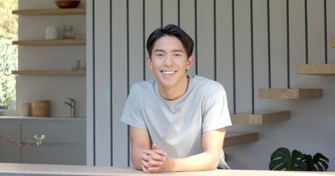Young Man Leaning on Counter in Minimalist Home Interior
