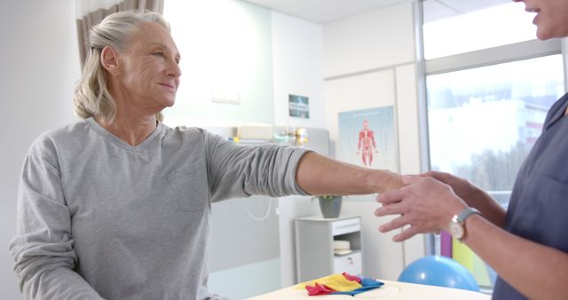 Senior woman receiving physical therapy from professional therapist in a modern clinic. Perfect for content related to healthcare, elderly care, physical therapy, rehabilitation, and medical practices.
