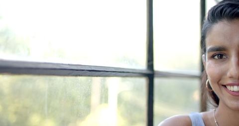 Young Woman Smiling by Window with Soft Lighting