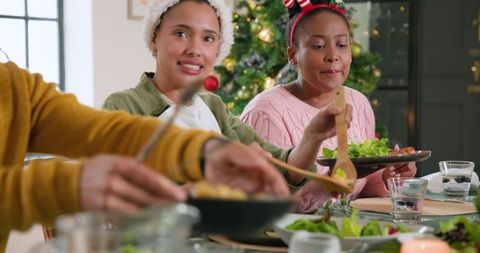 Diverse Friends Enjoying Holiday Meal Near Christmas Decor