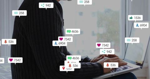 Mature man typing on laptop at bedroom window with social media notifications and alerts
