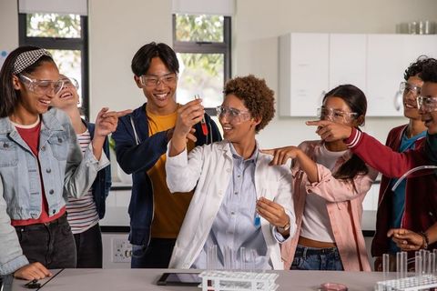 Diverse Students Engaged in Laboratory Experiment with Scientist