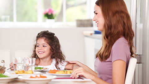 Mother and Daughter Enjoying Time at Dining Table in Kitchen