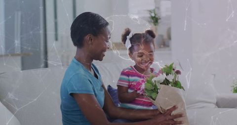 African american mother handing bouquet to smiling daughter on sofa with map overlay