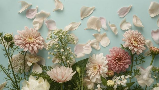 Pastel pink dahlia flat lay with scattered petals on soft blue backdrop, botanical