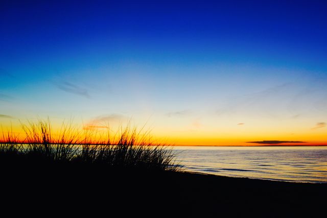 Serene Beach Sunset Over Calm Ocean Waters - Download Free Stock Photos Pikwizard.com