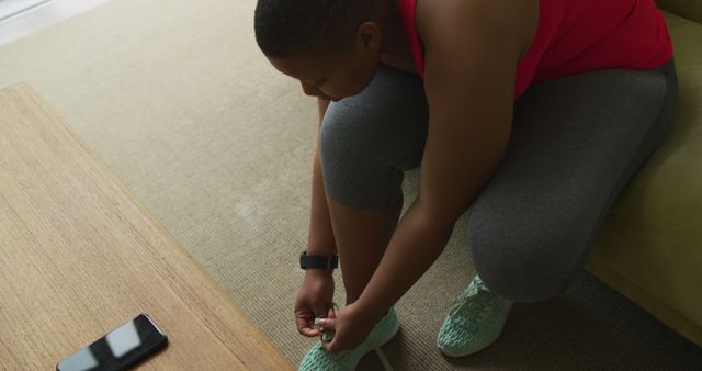 Woman in Activewear Tying Running Shoes at Home - Download Free Stock Images Pikwizard.com