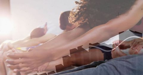 Backlit group yoga stretching in studio with urban skyline overlay, unity and fitness focus
