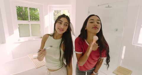 Sisters Enjoying Self-Care Rituals in Bright Modern Bathroom