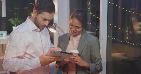Multicultural Colleagues Analyzing Data on Tablet in Modern Office