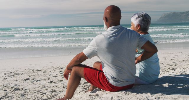 Senior african american couple sitting and embracing at the beach. healthy outdoor leisure time by the sea.