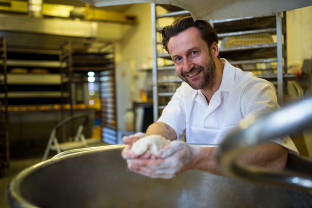 Portrait of smiling baker preparing dough