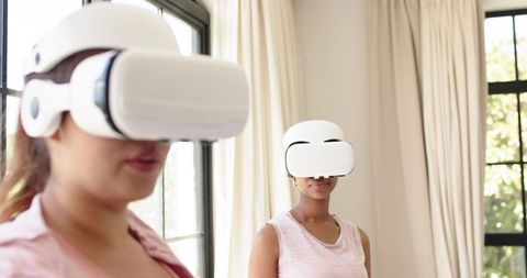 Women Wearing VR Headsets for Virtual Reality Experience in Bright Minimalist Space