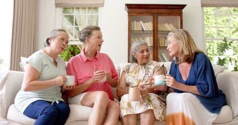 Senior Women Enjoying Coffee and Conversation on Sofa