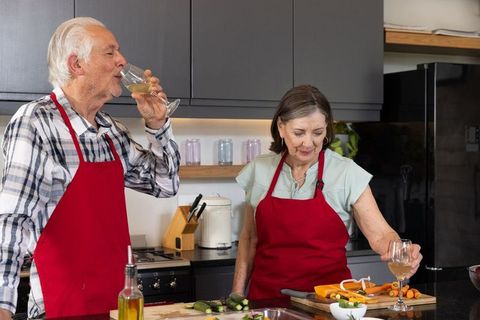 Senior Couple Cooking and Enjoying Wine in Cozy Kitchen
