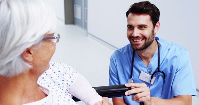 Nurse with Senior Patient in Hospital Corridor Smiling and Conversing - Download Free Stock Images Pikwizard.com