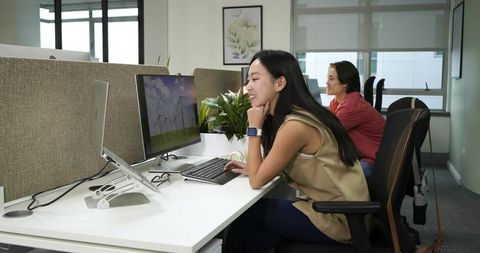 Woman Working at Office Desk Using Computer