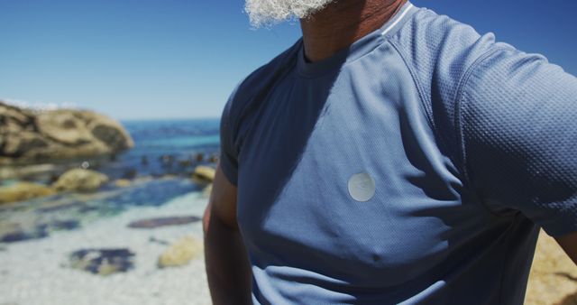 Man Wearing Sportswear Standing By Rocky Beach On Sunny Day - Download Free Stock Images Pikwizard.com