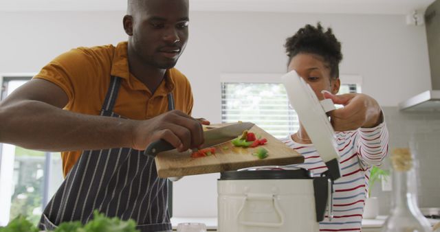 Image of happy african american couple cooking together in kitchen - Download Free Stock Photos Pikwizard.com