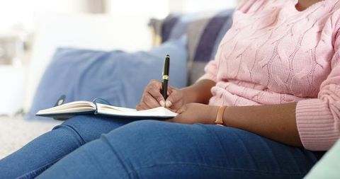 Focused Woman Writing Notes at Home in Cozy Attire - Download Free Stock Images Pikwizard.com