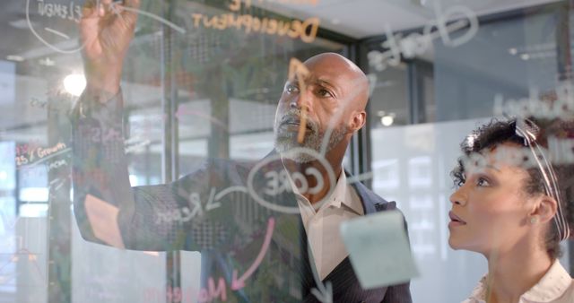 Focused Professionals Brainstorming Business Strategy Using Glass Whiteboard - Download Free Stock Images Pikwizard.com