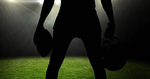Silhouette of Football Player with Helmet in Sports Stadium
