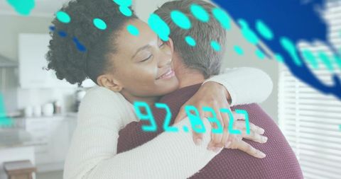 Multiracial couple embracing in sunlit kitchen with turquoise digital overlay and warm knitwear