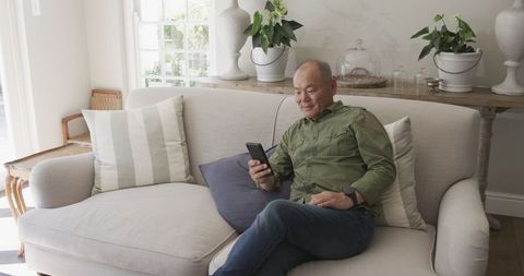 Senior Man Relaxing at Home with Smartphone