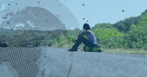 Woman Resting on Rural Road with Duffel Bag in Countryside
