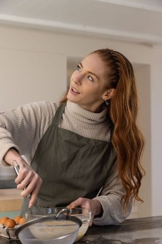 Red-Haired Woman Preparing Batter in Modern Home Kitchen