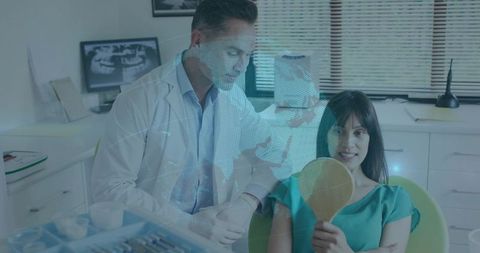Dentist examining patient holding mirror with holographic dental network overlay in clinic