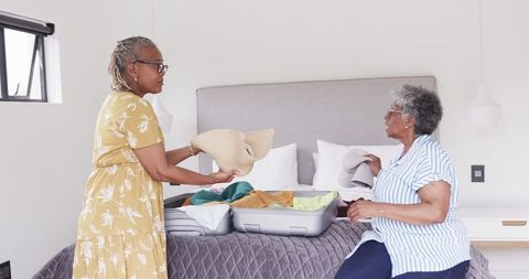Senior African American Women Unpacking Suitcase at Vacation Home