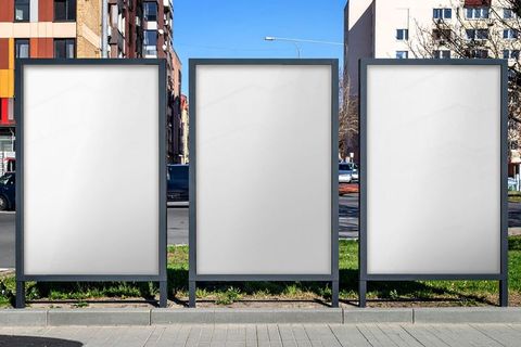 Three blank urban billboards along city sidewalk