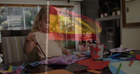 Creative Child Painting at Home with Spanish Flag Overlay