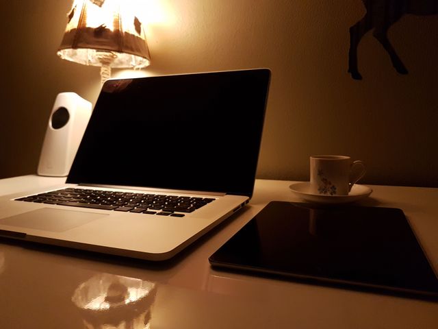 Cozy Evening Workspace with Laptop, Tablet, and Coffee Cup - Download Free Stock Photos Pikwizard.com