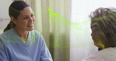 Hispanic caregiver listening to elderly patient with green digital overlay for health tech