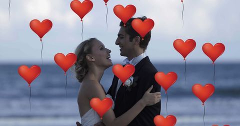 Romantic Bride and Groom with Heart Balloons on Beach