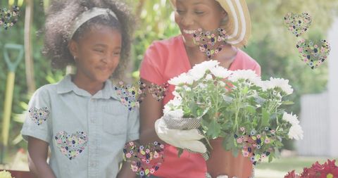 Smiling African American Mother and Daughter Gardening Together