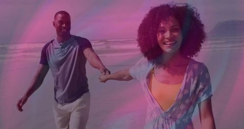 Joyful Couple Walking Hand in Hand by Seashore