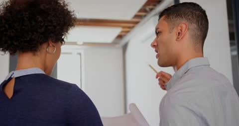 Biracial Colleagues Collaborating on Project with Papers
