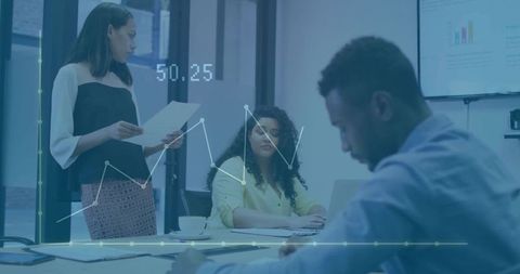 Diverse business team collaborating over data charts and presentation in modern boardroom