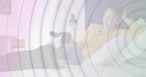 Smiling woman petting black-and-white dog on sofa with ripple overlay and copy space, cozy