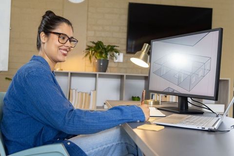 Asian woman designing 3d floor plan on monitor while writing notes at home office